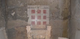 Ο θρόνος του τάφου του λεγόμενου «τύμβου Μπέλλα», στην ανατολική πλευρά του αρχαίου νεκροταφείου της Βεργίνας. Είναι εύρημα του Μανόλη Ανδρόνικου και του Αριστοτέλειου Πανεπιστημίου Θεσσαλονίκης του 1981. Είναι κατασκευασμένος από συναρμοσμένα μαρμάρινα μπλοκ και η πλάτη του δεν είναι πραγματική, αλλά ζωγραφισμένη στον πίσω τοίχο. Στην επιφάνεια του υποποδίου του είναι χαραγμένα τα περιγράμματα δύο πελμάτων.