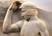 «Οδύσσειες» μαραθωνοδρόμων Βρέθηκε στο Σούνιο, κοντά στον ναό της Αθηνάς. Γύρω στο 460 π.Χ. Παριστάνεται νεαρός αθλητής γυμνός, να τοποθετεί ένα μετάλλινο στεφάνι στην κεφαλή. Ο αθλητής, ασφαλώς νικητής, αυτοστεφανώνεται ή ετοιμάζεται να αφιερώσει το νικητήριο έπαθλό του στη θεά Αθηνά ως ευχαριστήριο ανάθημα για τη νίκη του. (© Εθνικό Αρχαιολογικό Μουσείο/TAΠΑ).